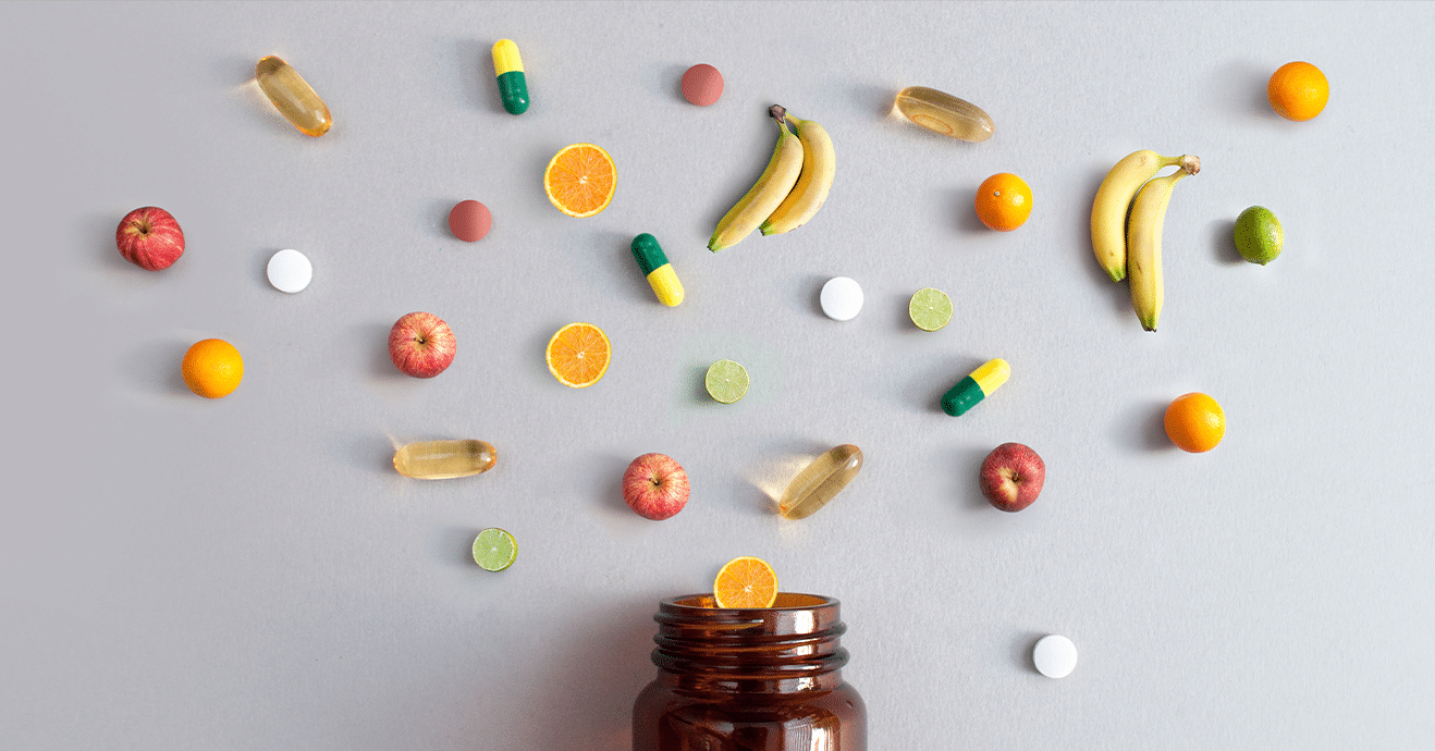 brown mason jar with various fresh ingredients floating above it