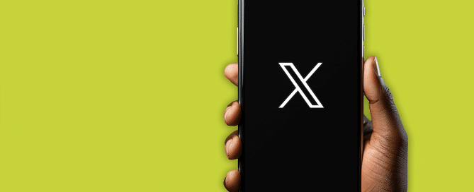 hand holding phone with X logo