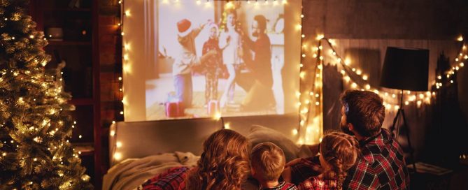 family watching movie on projector at the holidays